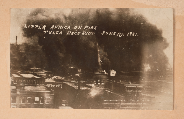 Schwarz-weiß-Foto einer Stadt mit Rauch, das Text in der Mitte und Gebäude unten zeigt.