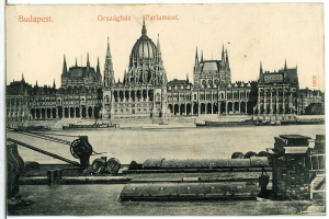 Schwarz-weiß-Postkarte des Ungarischen Parlamentsgebäudes in Budapest mit einem Boot im Vordergrund, umgeben von Bäumen und einem sichtbaren Himmel, mit Text auf der Postkarte.