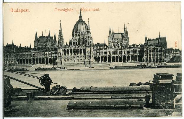 Schwarz-weiß-Postkarte des Ungarischen Parlamentsgebäudes in Budapest mit einem Boot im Vordergrund, umgeben von Bäumen und einem sichtbaren Himmel, mit Text auf der Postkarte.