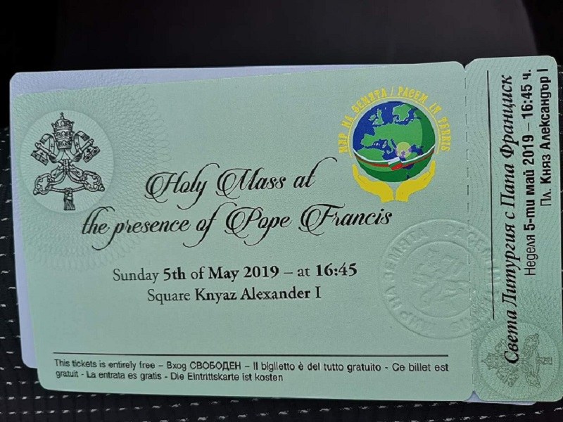 Schwarze Oberfläche mit einer Karte, auf der Text und ein Logo mit der Aufschrift "Heilige Messe in Anwesenheit von Papst Franziskus" zu sehen sind.