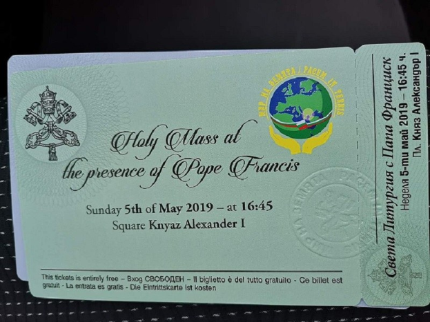 Schwarze Oberfläche mit einer Karte, auf der Text und ein Logo mit der Aufschrift "Heilige Messe in Anwesenheit von Papst Franziskus" zu sehen sind.