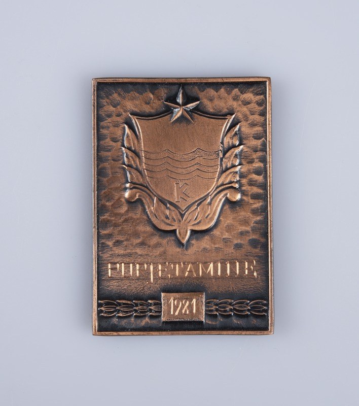Bronzeplatte mit dem Wappen der Sowjetunion und Text in der Mitte des Bildes.