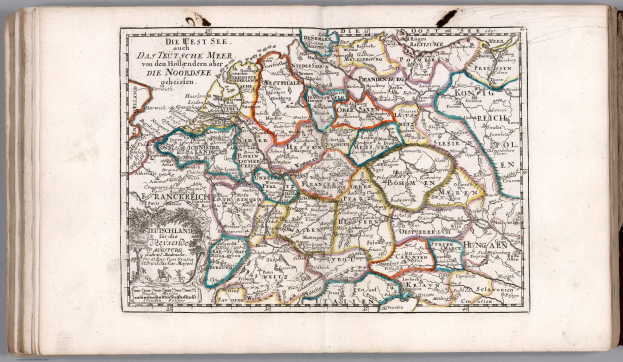 Offenes Buch mit einer detaillierten Karte von Deutschland mit geografischen Merkmalen wie Flüssen, Bergen und Städten, begleitet von beschreibendem Text.