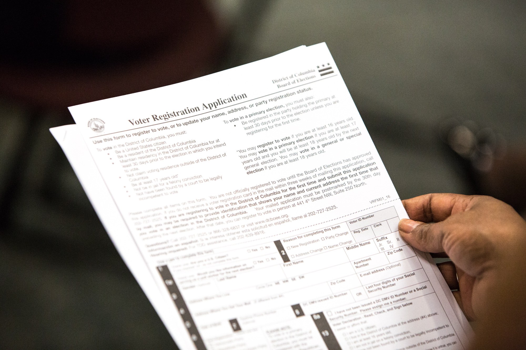 Person mit einem ausgefüllten Wählerregistrierungsformular in der Hand.