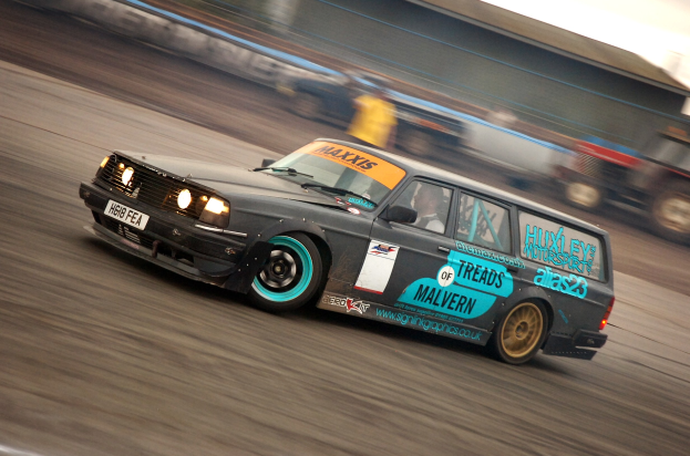Ein Auto, das mit hoher Geschwindigkeit auf einer Rennstrecke fährt und von anderen Fahrzeugen umgeben ist, mit einem unscharfen Hintergrund.