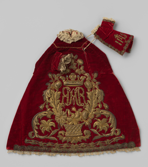 Ein roter Samtmantel mit goldener Stickerei und einer Krone, der aufwendige Designs zeigt, vor einem wei├čem Hintergrund.