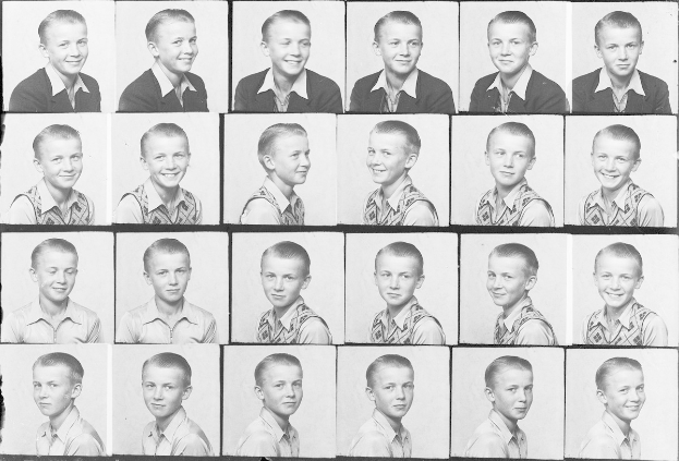 Ein Schwarz-Weiß-Foto eines strahlenden jungen Jungen mit ordentlich gekämmtem Haar, hellen Augen und einem Ausdruck der Freude.