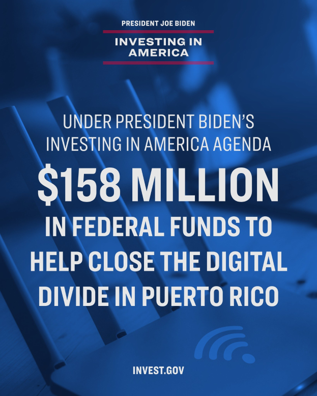 Plakat mit der Aufschrift "Unter dem Investing in America-Programm von Präsident Biden: 158 Millionen Dollar Bundesmittel, um die digitale Kluft in Puerto Rico zu schließen" mit einem Laptop, Papieren und einem Kaffeebecher auf einem Tisch davor.