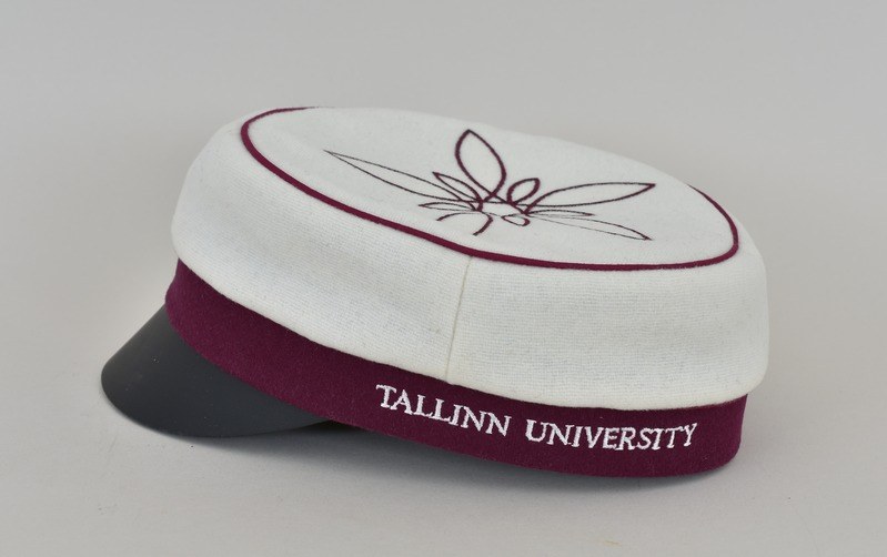 Eine weiße und maronenfarbene Mütze mit 'Tallinn University' darauf vor einem weißen Hintergrund.