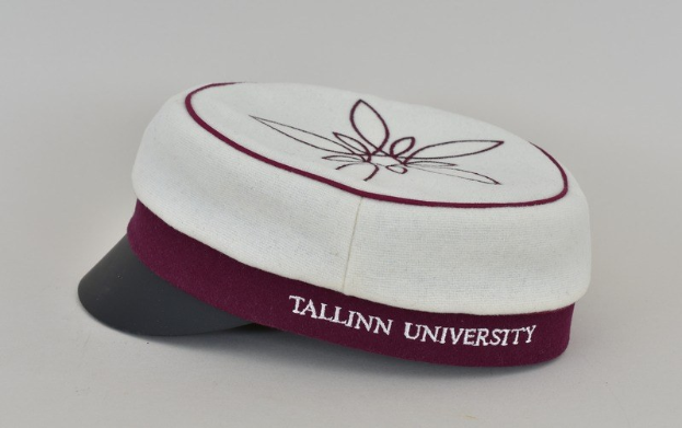 Eine weiße und maronenfarbene Mütze mit 'Tallinn University' darauf vor einem weißen Hintergrund.