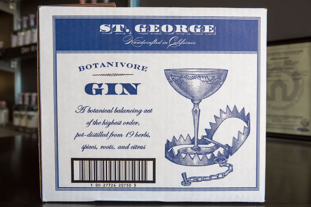 Ein Plakat mit Text wird vor Regalen mit vielen Flaschen angezeigt.