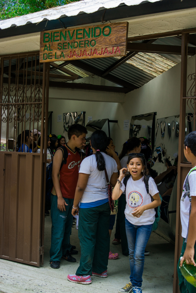 Ein Geschäft mit einer Fassade aus Wellblech, einem Schild oben mit Text und Menschen drinnen.