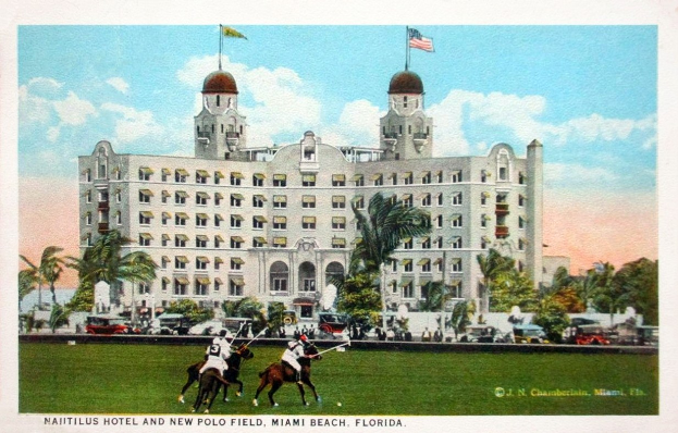 Eine Vintage-Postkarte des Nautilus Hotels und des Neuen Polo Feldes in Miami Beach, Florida, zeigt ein Gebäude mit Fenstern, Bäumen, Fahrzeugen, Menschen und einem bewölkten Himmel mit Text unten.