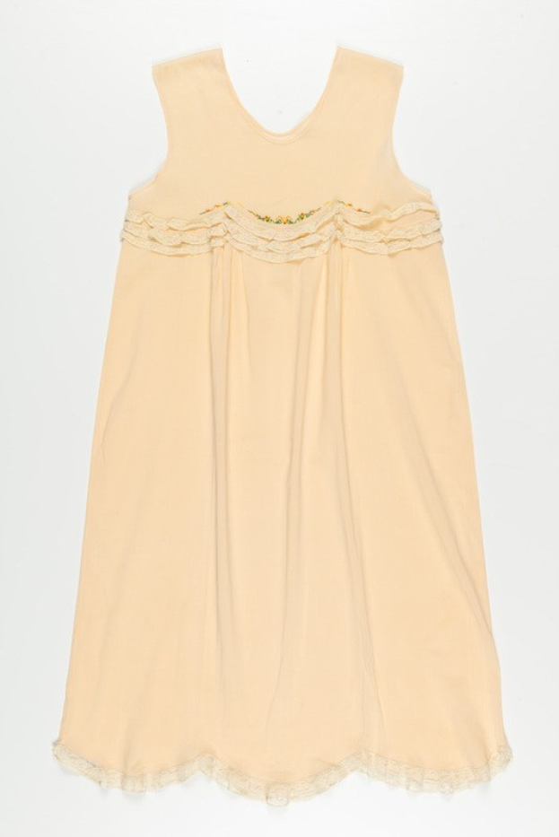 Ein cremefarbenes Nachthemd mit zartem Spitzenbesatz am Halsausschnitt, hergestellt aus weichem, leichtem Stoff mit einem dezenten Schimmer.