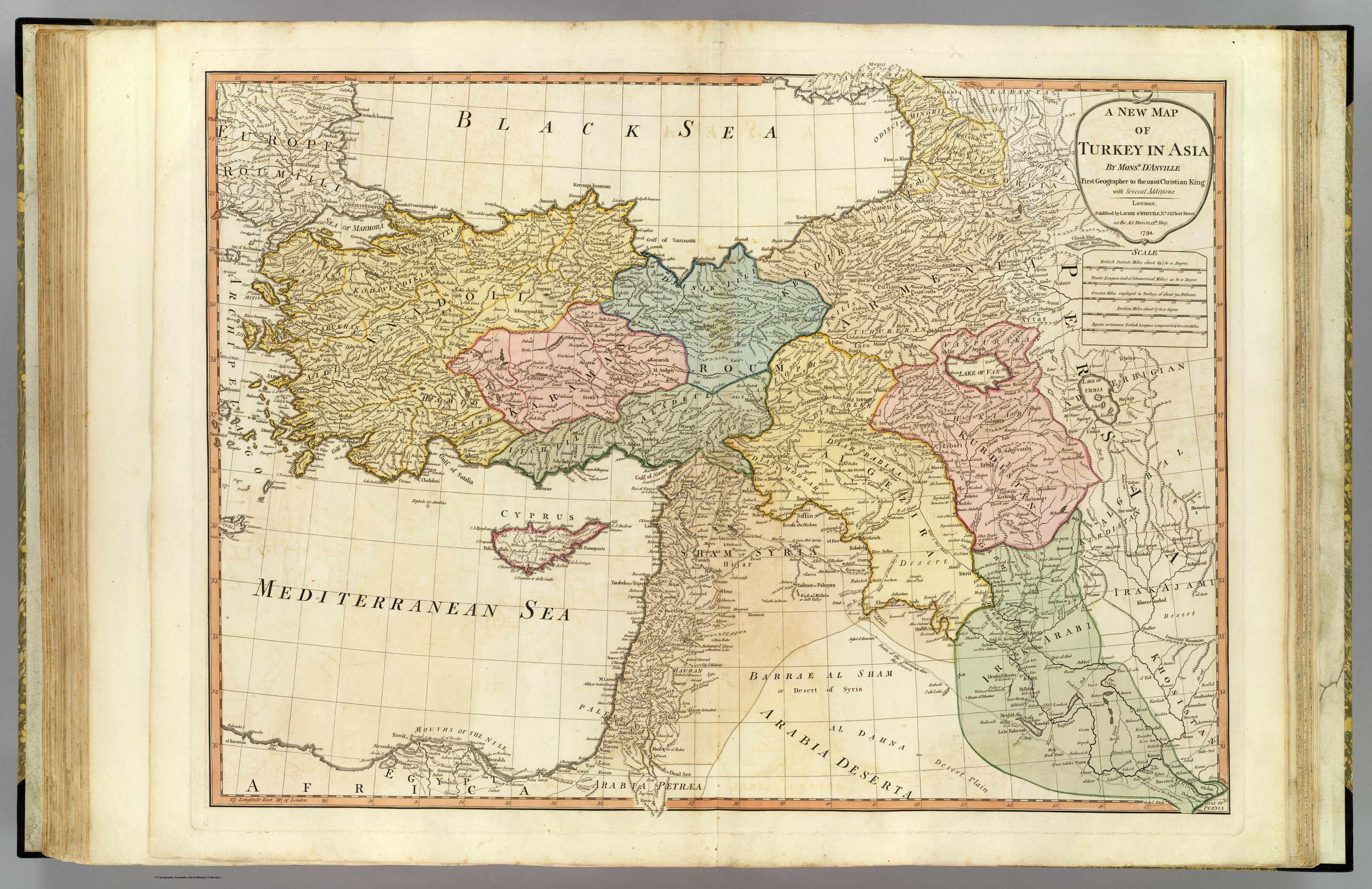 Offenes Buch mit detaillierter Karte von Türkei in Asien auf grauem Hintergrund, mit sichtbarem Text auf dem Papier.