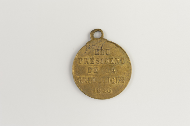 Goldmedaille mit der Inschrift "Präsident der Republik" vor einem weißen Hintergrund.