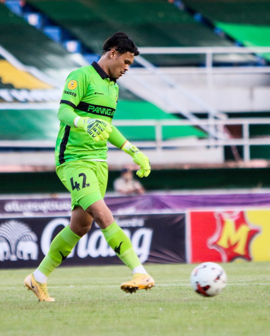 Ein Torwart in grüner Uniform kickt einen Fußball auf einem Rasenfeld in einem Stadion, mit Bannern im Hintergrund, die "Chivas USA vs Mexico City, 3-1, Copa Libertadores" anzeigen.