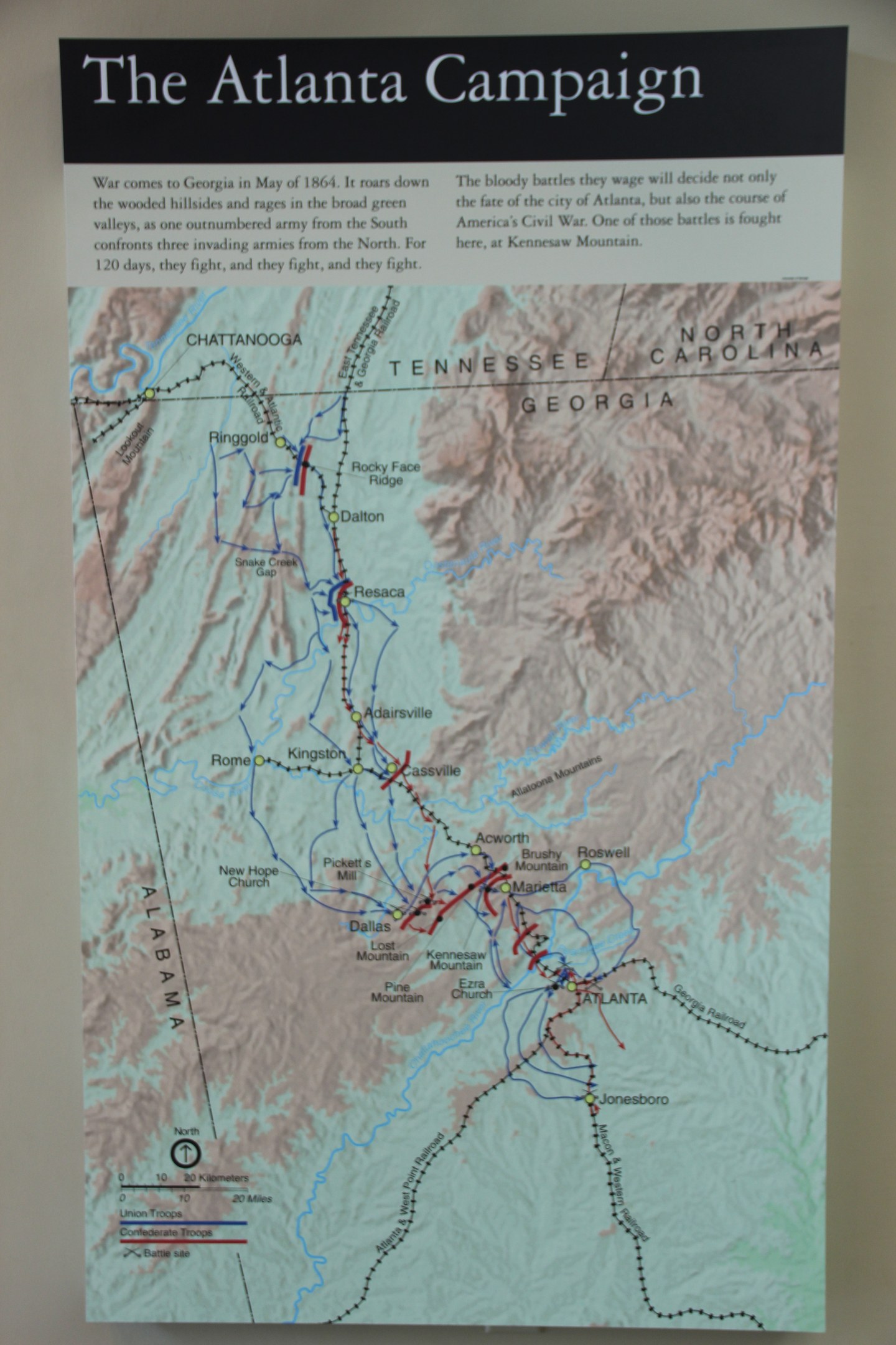 Ausführliches Plakat an einer Wand mit einer Karte der Atlanta-Kampagne, einschließlich Straßen, Städten und Sehenswürdigkeiten, mit begleitendem Text über das Datum, die Zeit und den Ort der Kampagne.