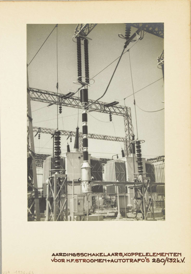 Schwarzes und weißes Foto einer elektrischen Umspannstation mit Transformatoren und Drähten, das Text am unteren Rand enthält.