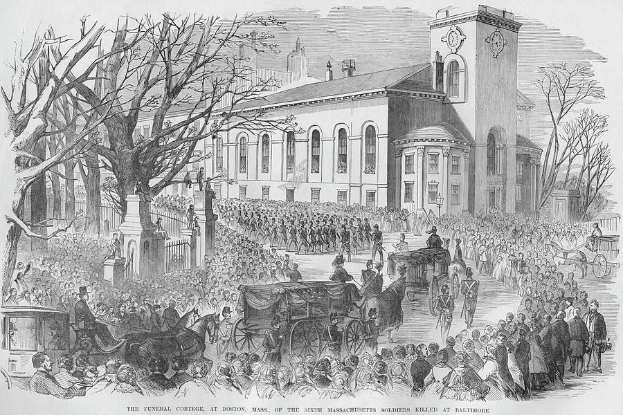 Schwarze und weiße Zeichnung einer Beerdigungsprozession mit einer Menge vor einem Gebäude, Pferdewagen und Bäumen, mit Text unten, der lautet: "Die Beerdigungsprozession in Boston, Mass. der sechsten Massachusetts-Soldaten, die in Baltimore getötet wurden."