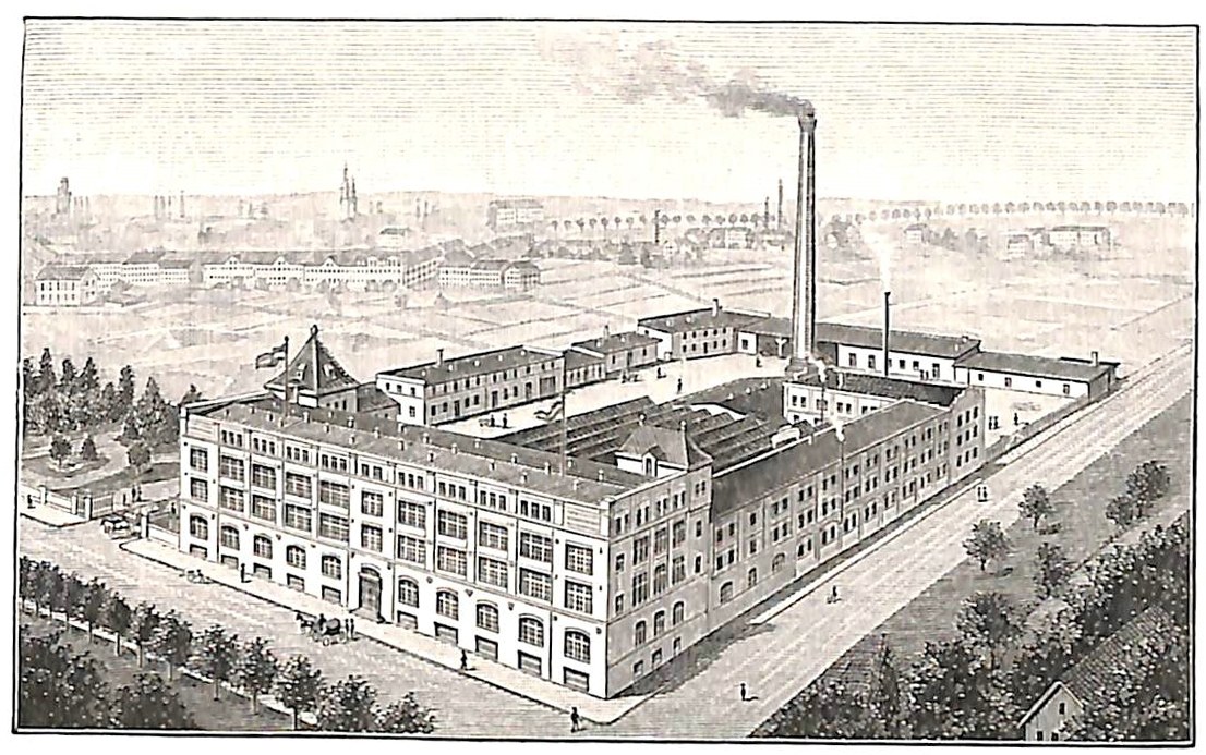 Alte Fabrik mit großem Hauptgebäude umgeben von Bäumen und Text unten.