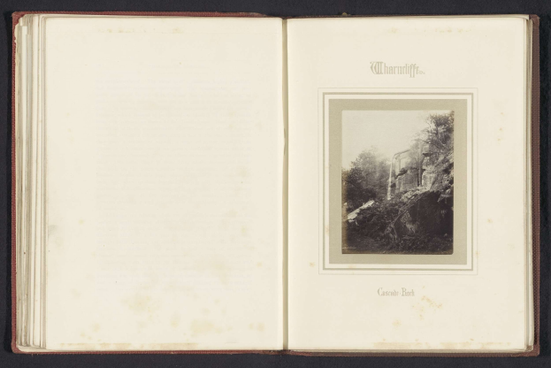 Schwarz-weiß-Fotografie eines Wasserfalls, der eine felsige Klippe hinabstürzt und von Bäumen umgeben ist, in einem Buch mit dem Titel "Cascade Park"
