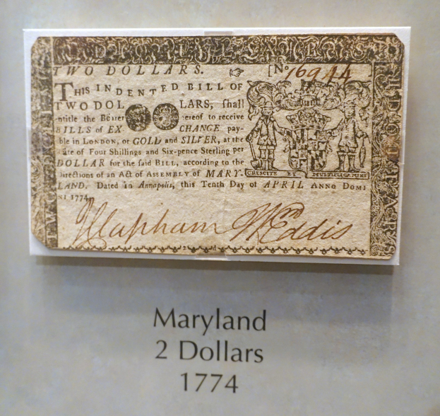 Eine Maryland-Zweidollarnote von 1774 in einer Glasvitrine mit lesbarer Schrift.