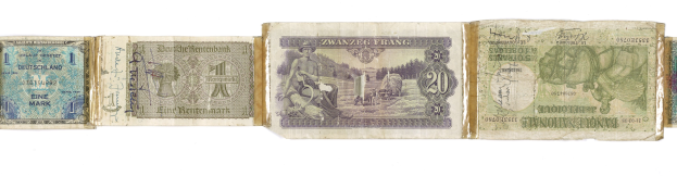 Altes Buch mit verschiedenen Nennbeträgen alter deutscher Banknoten darauf gestapelt.