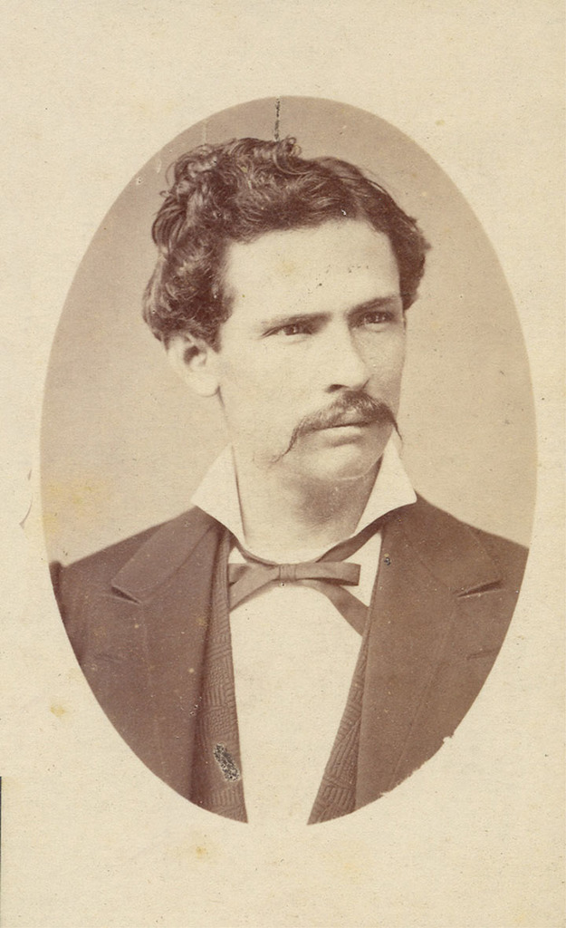 Ein Schwarz-Weiß-Foto eines Mannes in Hemd und Anzug.