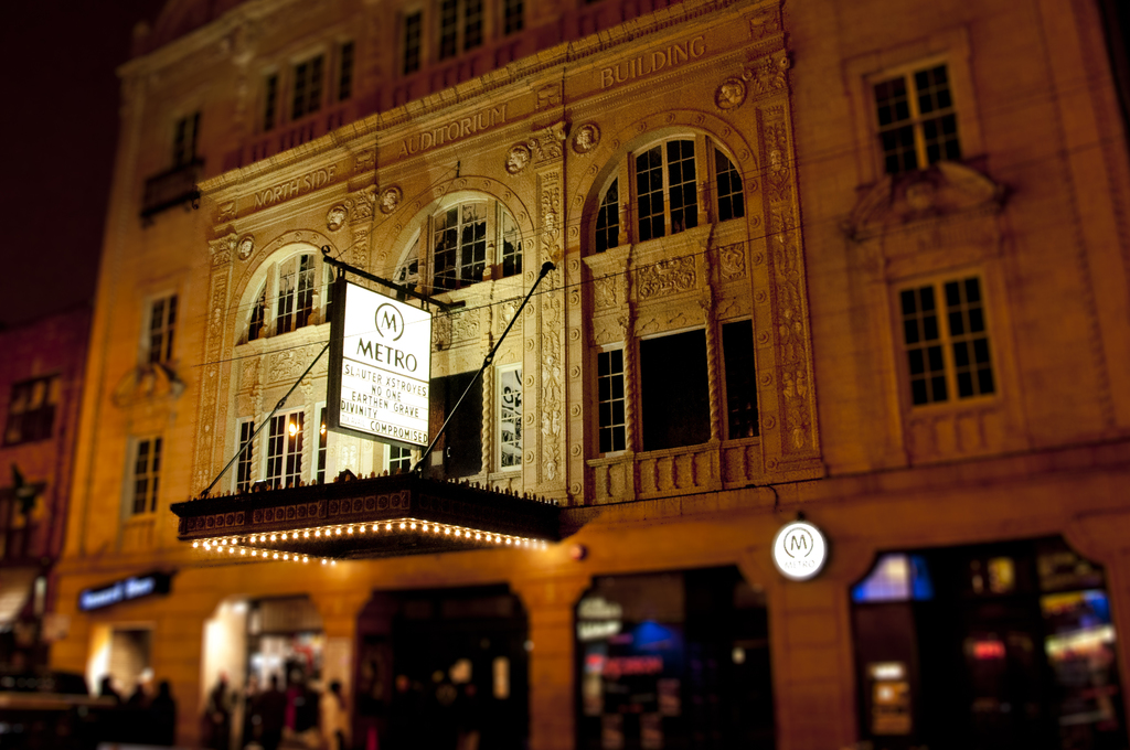 Ein gelbes Gebäude mit Geschäften unten und einem weißen Schild, auf dem 'Metro' steht.