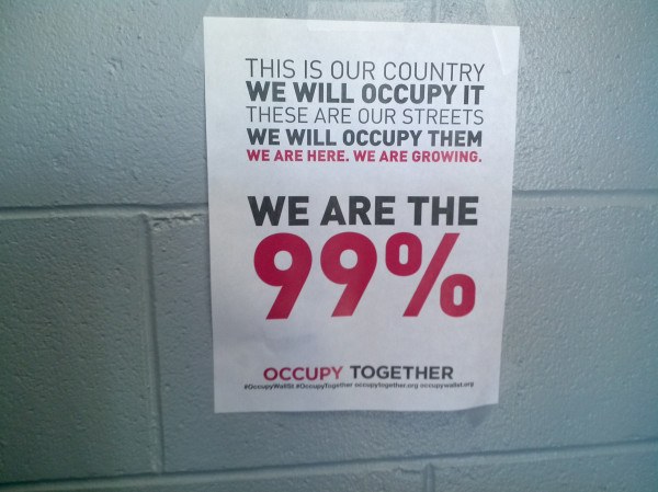 Plakat mit fettem schwarzem Text, der "Occupy Wall Street" und "Wir sind die 99%" zeigt.