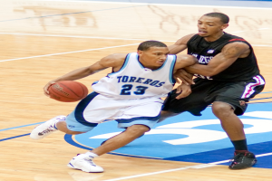 Zwei Personen spielen Basketball, wobei eine Person den Ball in der Mitte hält.